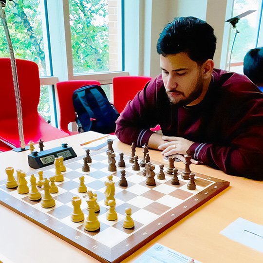 Coach Angel Salazar studying a chess position